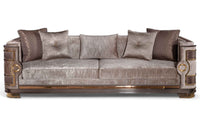 Luxurious Mimosa Chester sofa with plush upholstery in a metallic taupe finish, featuring deep cushions, ornate wooden armrests with gold accents, and matching decorative pillows, designed by Ali Guler Furniture.
