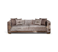 Elegant Mimosa Chester sofa featuring a metallic taupe velvet finish, decorative gold accents on the wooden frame, and five coordinating throw pillows in neutral and dark tones.